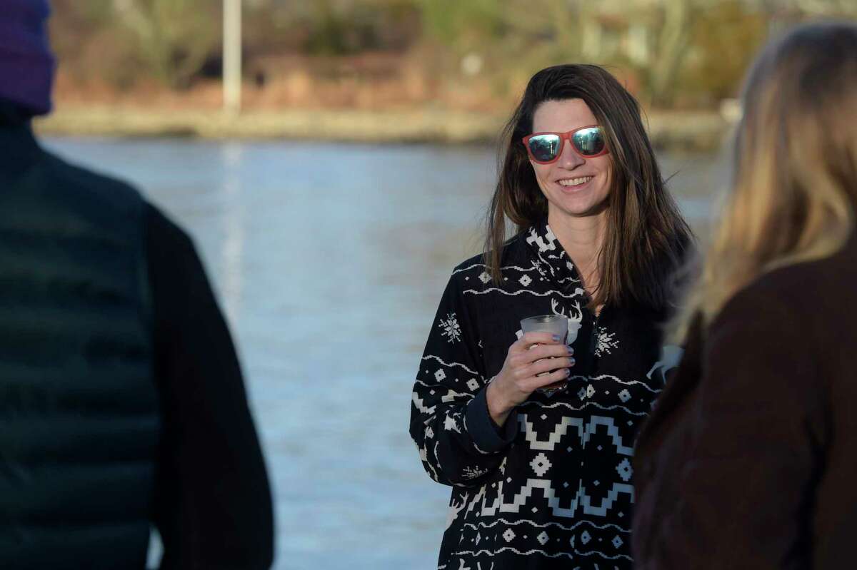 Catrin Bowtell, of Darien, enjoys a cup of tea after participating in a polar plunge at Pear Tree Point Beach. The plunge, organized by Carozza Fitness owner Michael Carozza, benefited Animals R Us. Sunday, January 1, 2023, Darien, Conn.