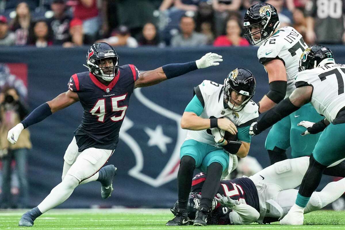 Jacksonville Jaguars quarterback C.J. Beathard (3) is sacked by Houston Texans defensive end Jerry Hughes (55) and linebacker Ogbonnia Okoronkwo (45) during the second half an NFL football game Sunday, Jan. 1, 2023, in Houston.