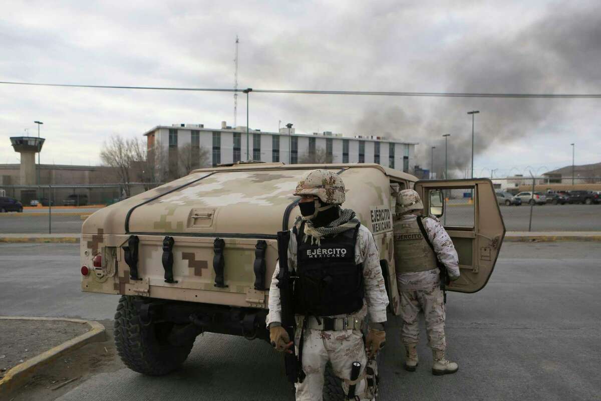 Mexican soldiers stand guard outside a state prison in Ciudad Juarez, Mexico, Sunday Jan 1, 2023. Mexican soldiers and state police regained control of a state prison in Ciudad Juarez across the border from El Paso, Texas after violence broke out early Sunday, according to state officials.