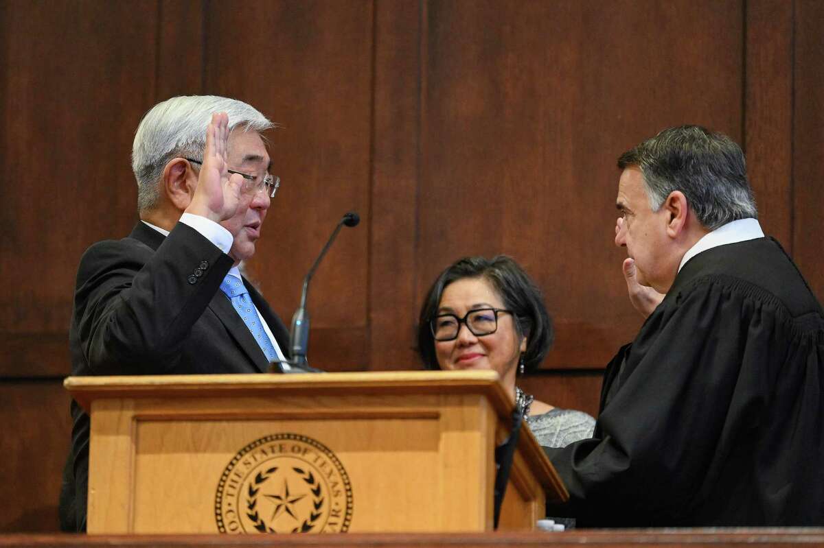Peter Sakai, left, is sworn in as Bexar County judge by U.S. District Judge Orlando L. Garcia at the county courthouse on Sunday.