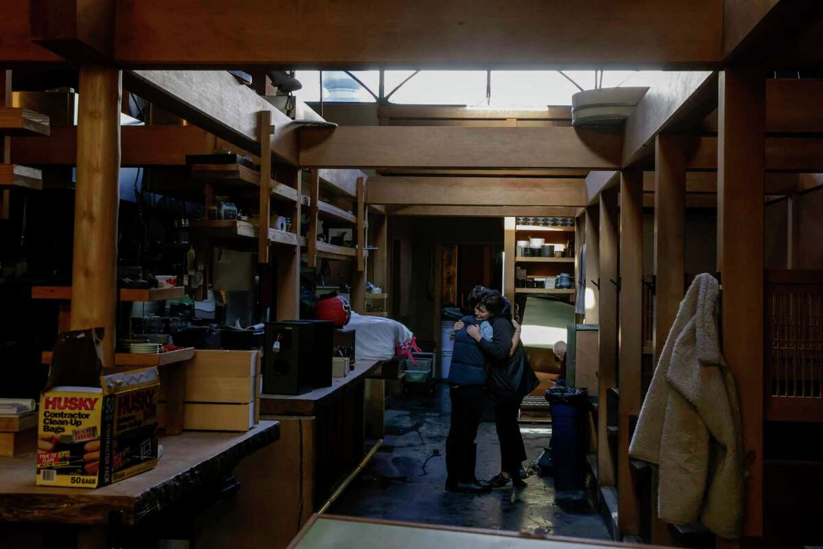 Jenny Wapner embraces chef Mamiko Kobayashi at Rintaro on New Year’s Day in San Francisco, Calif. on Sunday, Jan. 1, 2023. The Bay Area transitioned to cleaning mode after near-record rainfall hit San Francisco. The restaurant was flooded with several feet of water.