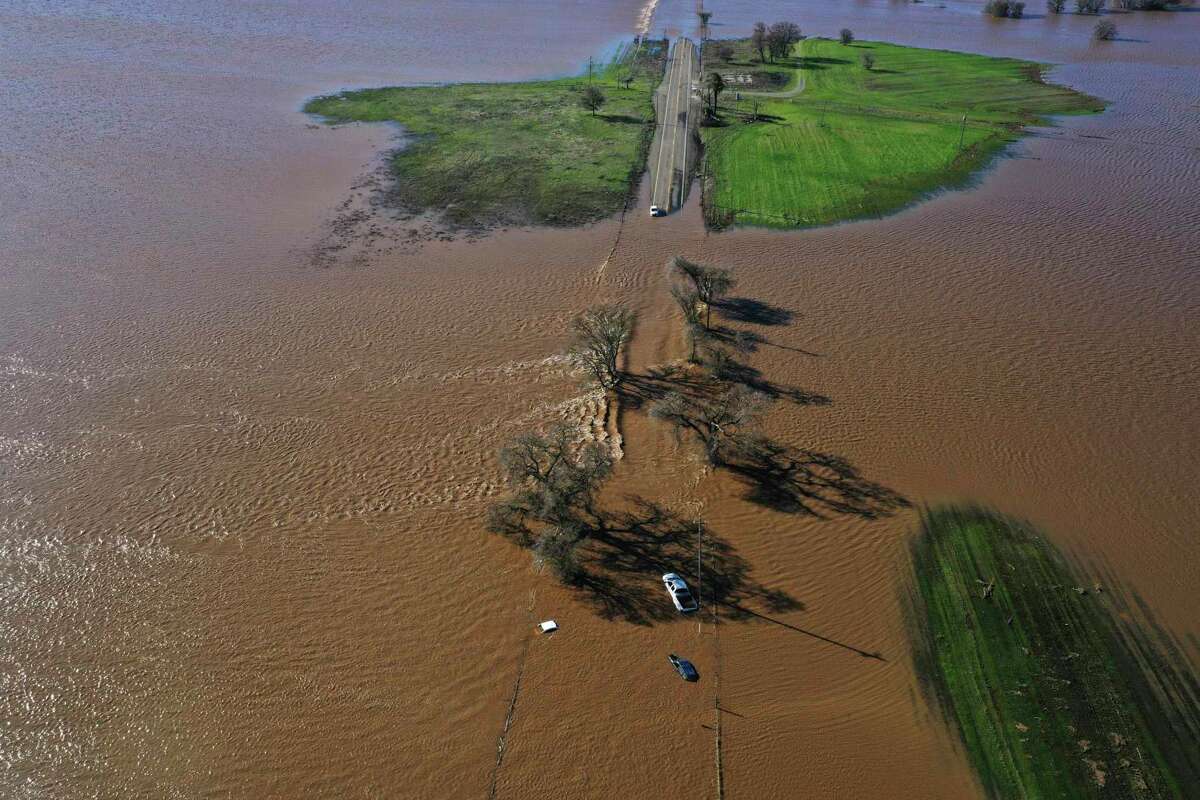 三个汽车淹没在迪拉德大道西99号公路在萨克拉门托县南部威尔顿,加利福尼亚州,星期日,2023年1月1日暴雨在新年前夕防洪堤。周六的系统比较温暖和湿润,而本周风暴会冷,汉娜Chandler-Cooley说,美国国家气象局气象学家在萨克拉门托。萨克拉门托地区将总共收到4 - 5英寸(10到13厘米)上周下雨,Chandler-Cooley说。(赫Amezcua /萨克拉门托蜜蜂通过美联社)