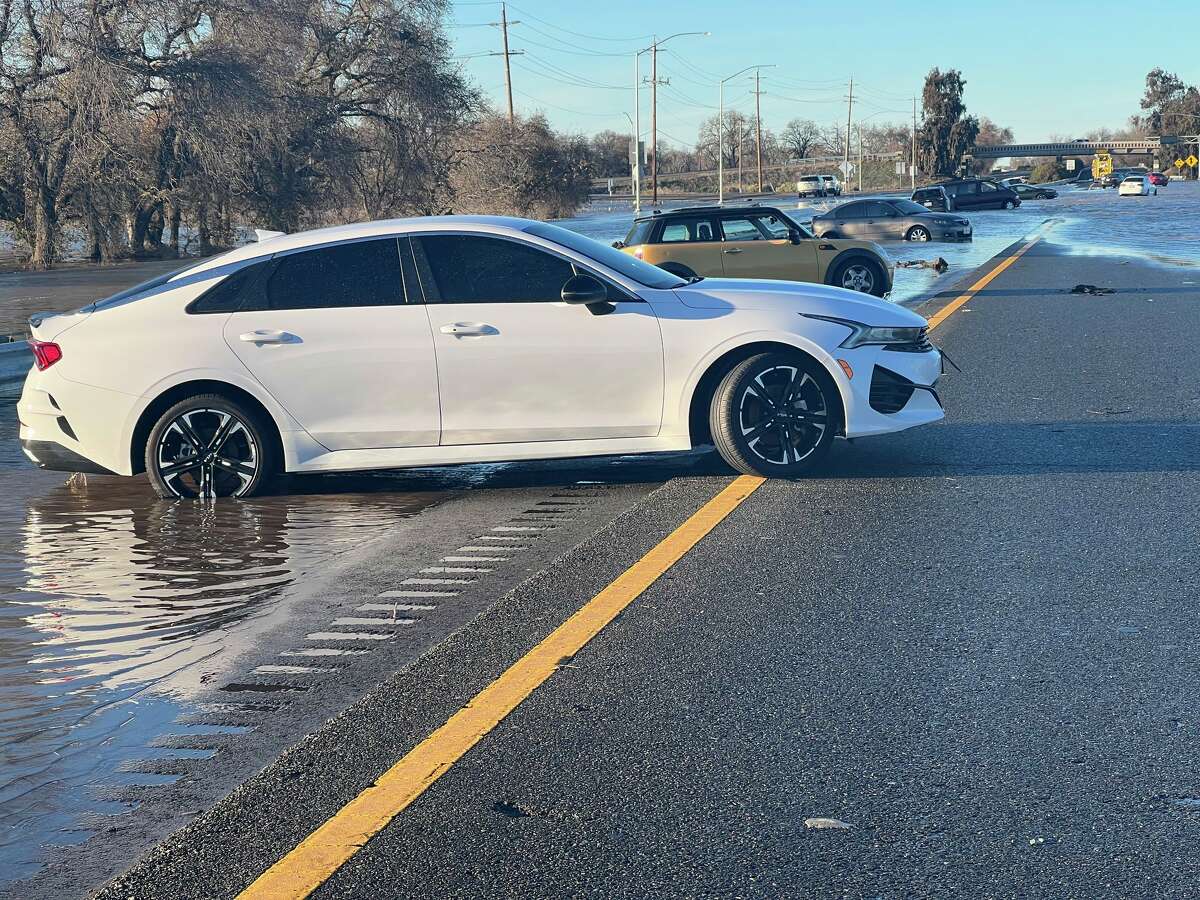 A car was stuck in a puddle covering Highway 99 on January 1 after an atmospheric river flooded Northern California on December 30-31, 2022.