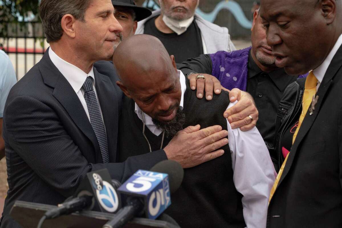 Robert Adams Sr., father of slaying victim Rob Adams, is comforted after speaking at a press conference about a lawsuit filed against the San Bernardino Police Department in Los Angeles.