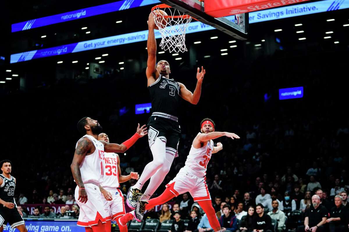 The Spurs' Keldon Johnson drives past the Brooklyn Nets' Seth Curry and Kyrie Irving during the first half of Monday night’s game in New York.