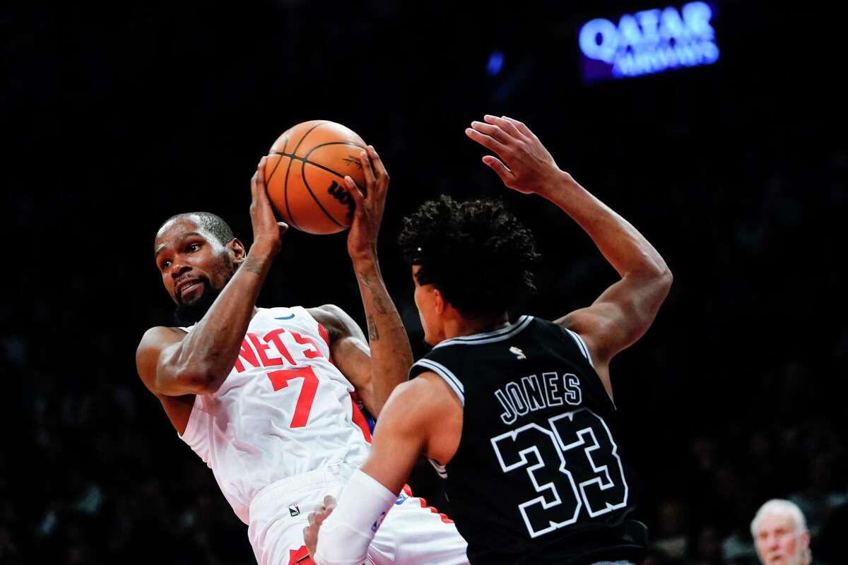 The Brooklyn Nets' Kevin Durant, left, protects the ball from the Spurs' Tre Jones during the second half of Monday night’s game in New York.