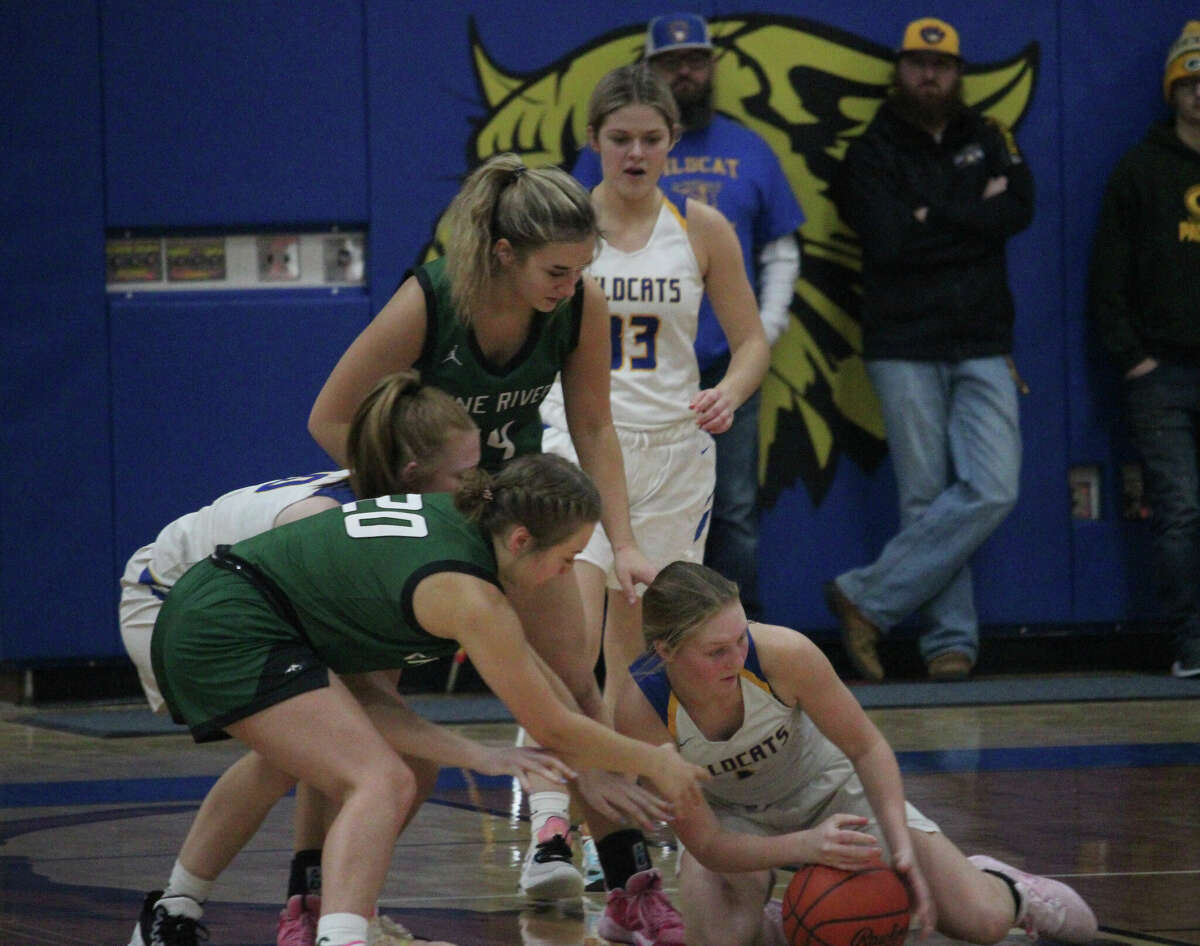 Evart's Addy Gray (right) fights for the ball against Pine River's Taylor Stewart (20) during Monday's game.