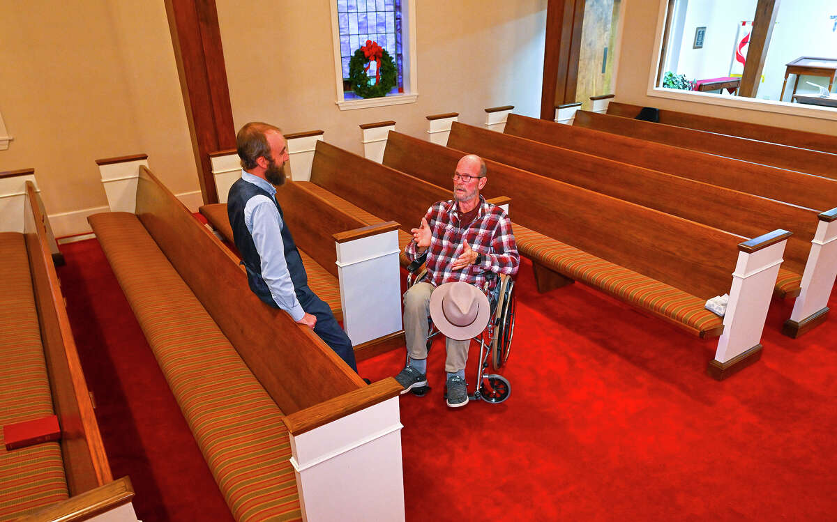 Jerry Lamb, who has a spine condition, talks to Pastor Adam Kelchner at Camden First United Methodist Church in Tennessee. The church had a couple of pews cut in half so those who use a wheelchair, walker or other aid still can sit with the rest of the congregation.