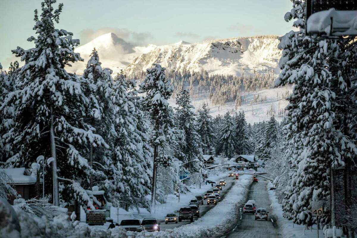 Vehicles travel along a snow-lined Route 50 in South Lake Tahoe on Sunday after a winter storm pelted the region with a large amount of snow. Snow pack is far above normal across the Sierra.