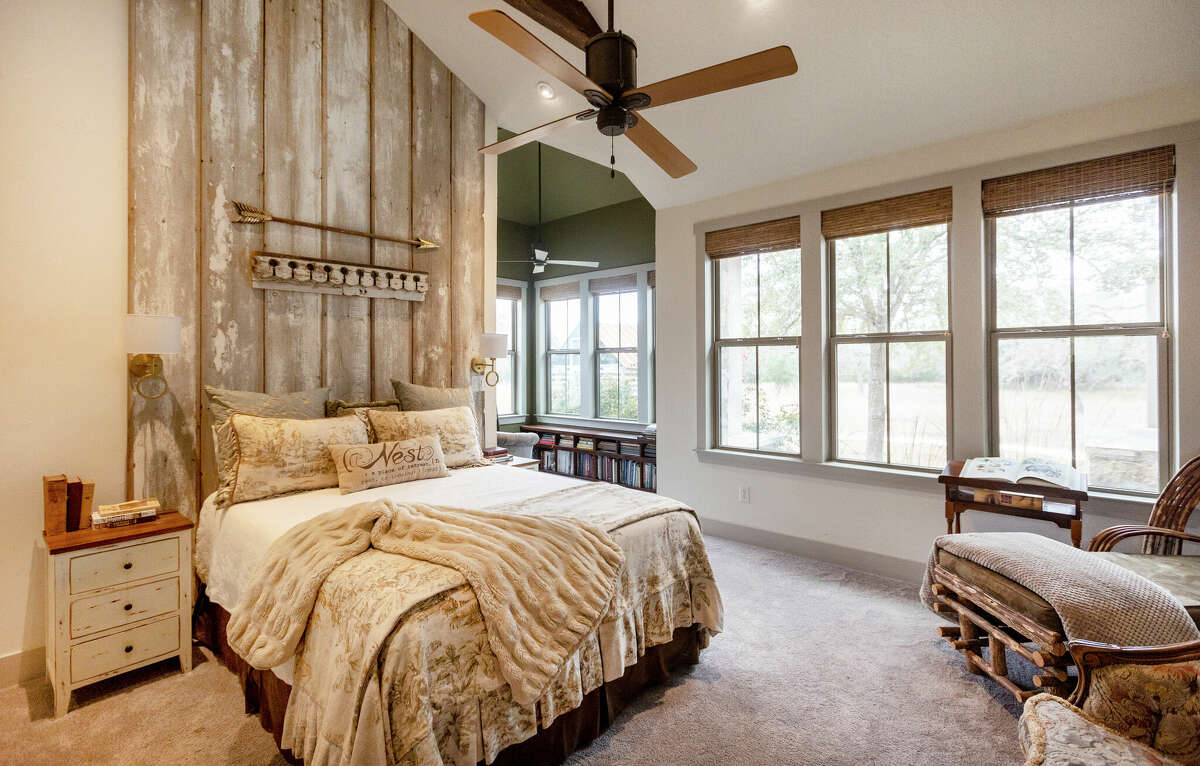 The primary bedroom, while mostly modern, still has the rustic touch of a scraped, reclaimed wood headboard that rises to the ceiling. 