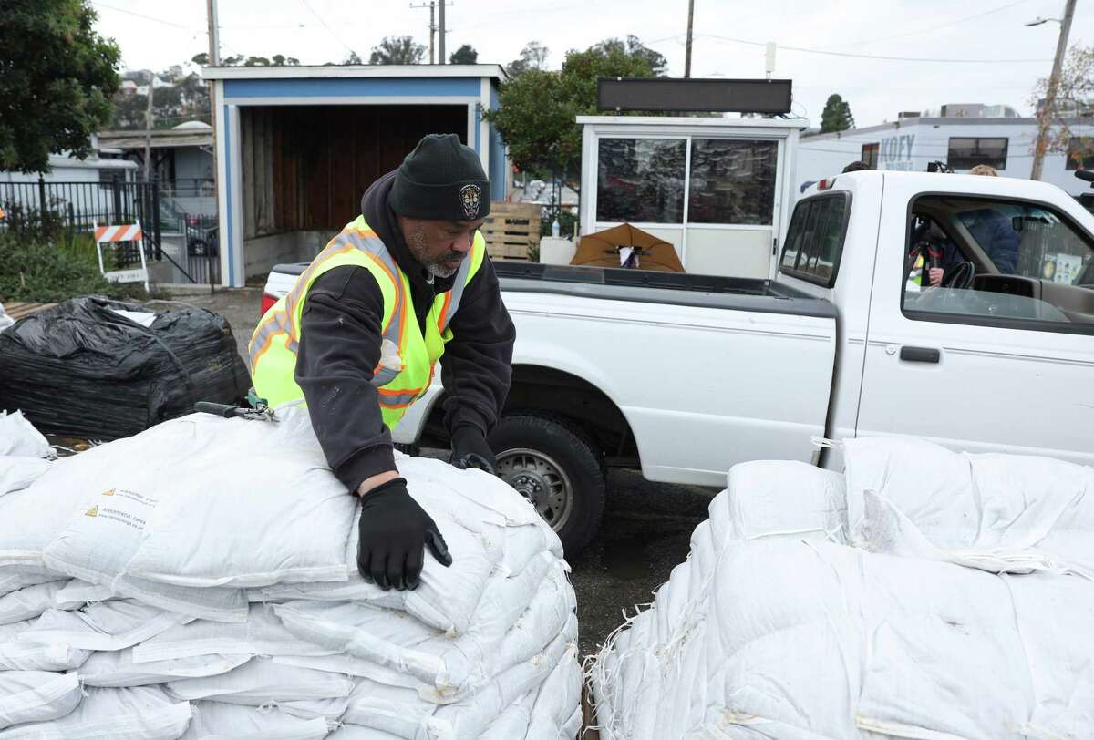 A San Francisco Department of Public Works worker loads sandbags into a truck Tuesday, Jan. 3, 2023, in San Francisco. The Bay Area is preparing for another huge winter storm that is expected to arrive Wednesday.