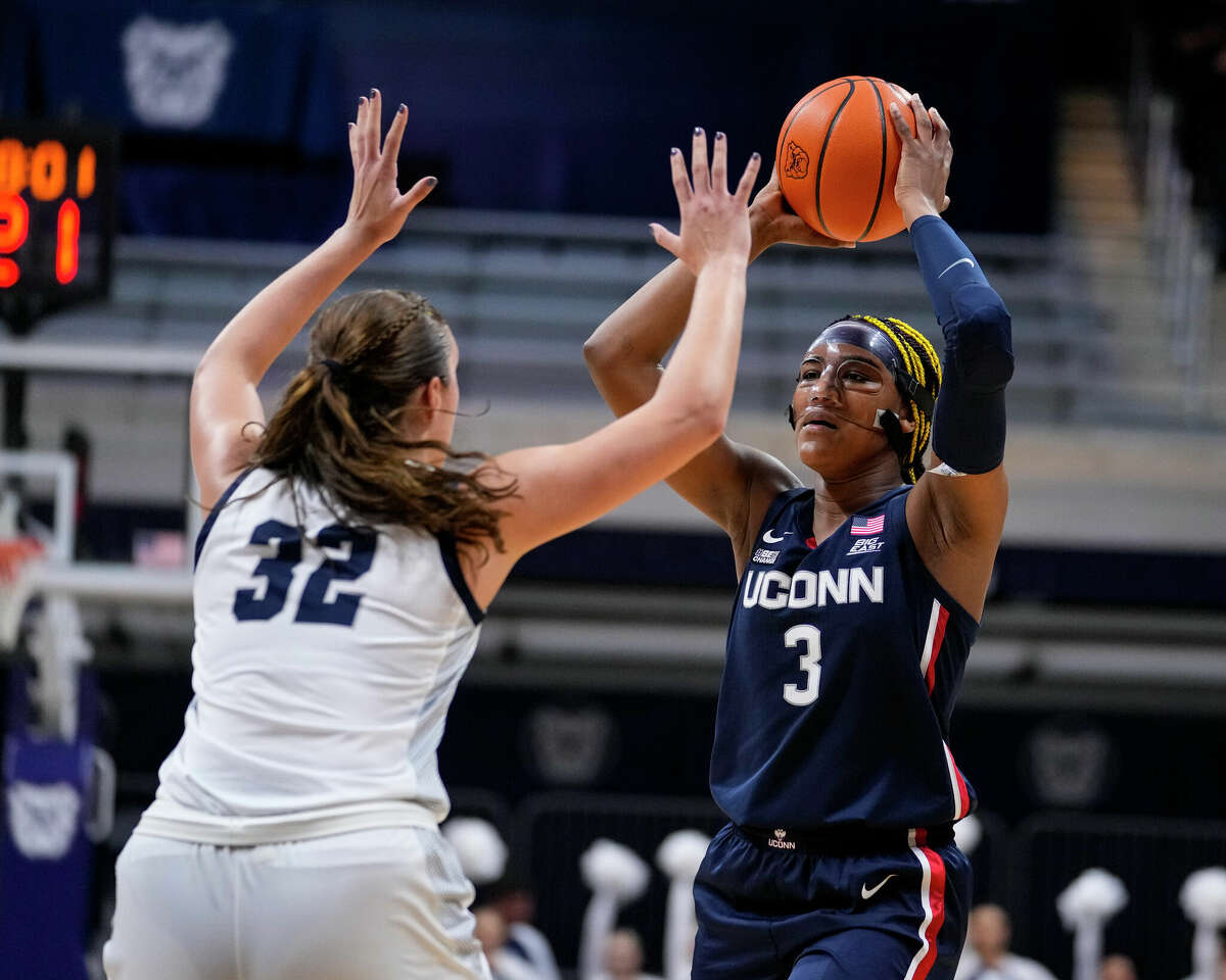 UConn forward Aaliyah Edwards (3) makes a pass over Butler forward Sydney Jaynes (32) uring the first half of an NCAA college basketball game in Indianapolis, Tuesday, Jan. 3, 2023. (AP Photo/Michael Conroy)