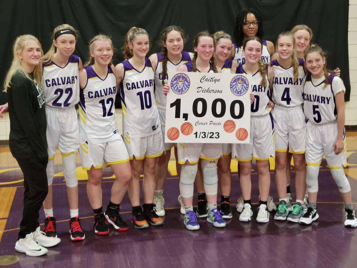 CBA's Caitlyn Dickerson poses alongside her teammates with a sign commemorating her 1,000th career point following Tuesday's win over Farwell, Jan. 3, 2023.