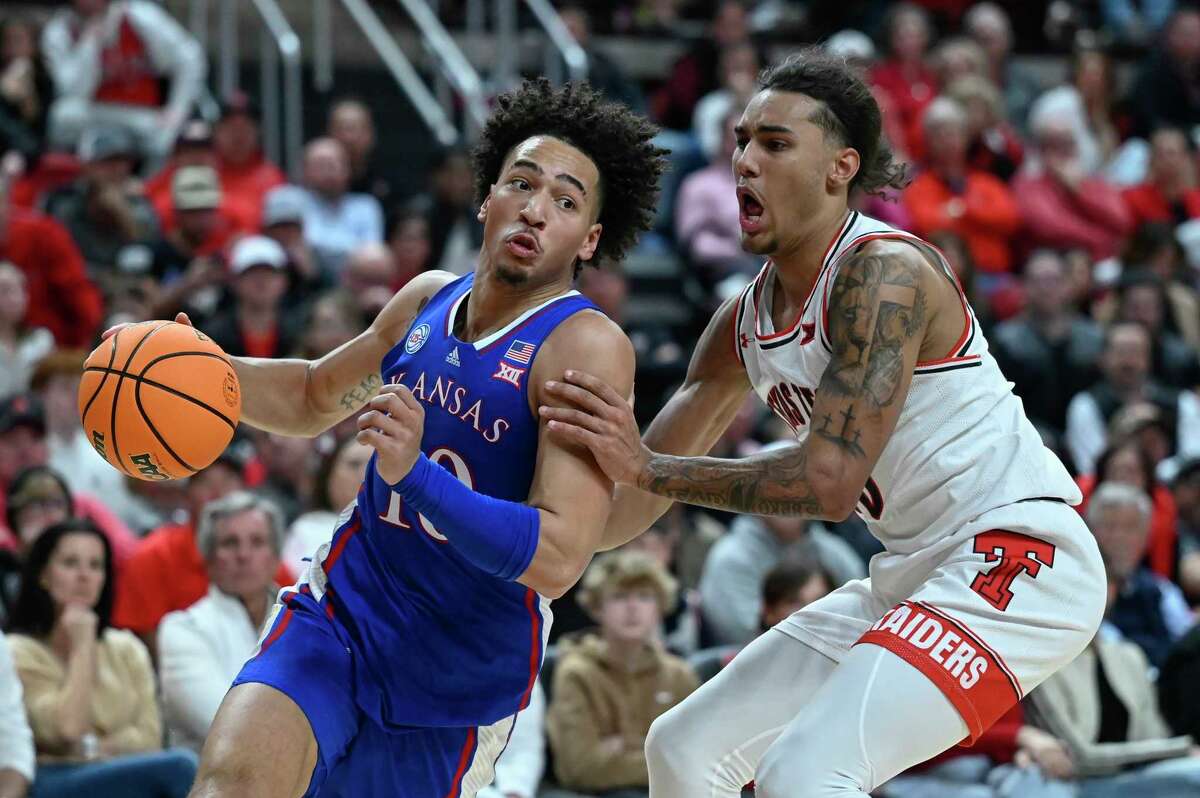 Kansas forward Jalen Wilson drives to the basket against Texas Tech guard Jaylon Tyson during the second half of an NCAA college basketball game, Tuesday, Jan. 3, 2023, in Lubbock, Texas.
