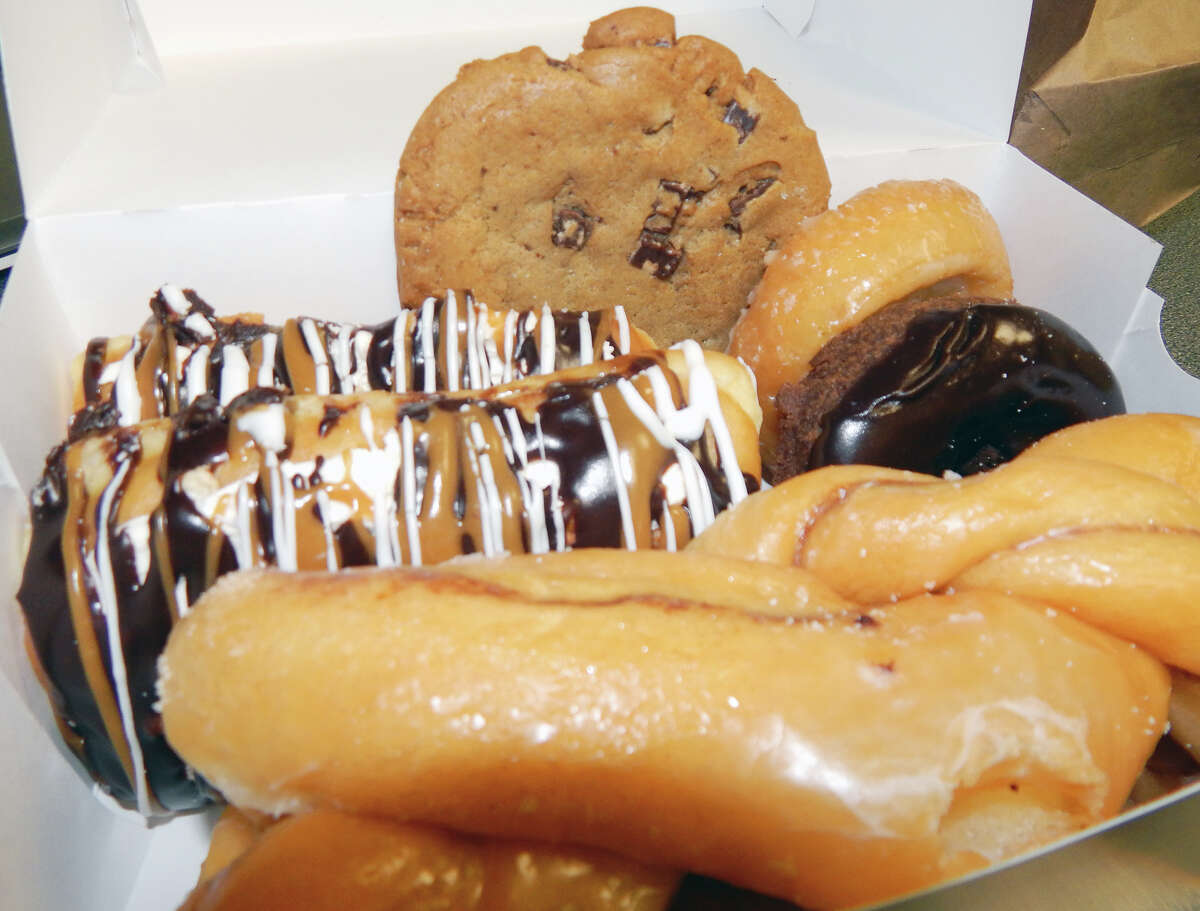 Doughnuts and a chocolate chip cookie from Kim's Other Place doughnut shop and bakery fill a carryout box. Many items that were on the menu of the former SafeCo Donuts and Bakery remain on the menu at Kim's.