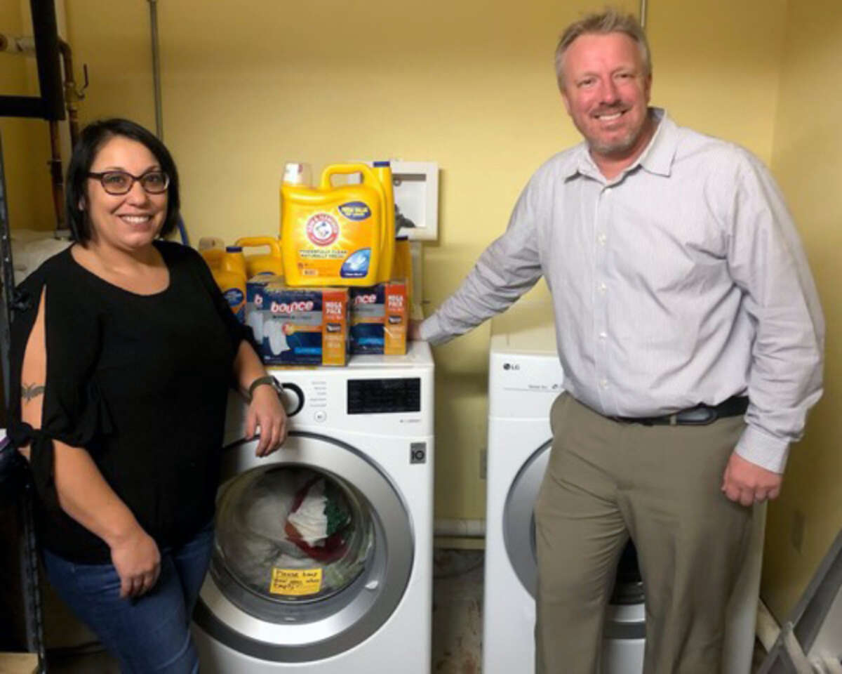 Big Rapids Elks President Josh Eling (right) poses for a photo with Our Brother's Keeper shelter director Nicole Alexander after the community organization donated a washer and dryer to the homeless shelter.
