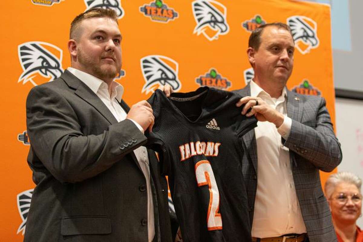 Kris McCullough, left, holds a Falcons jersey after being introduced as the new head football coach of UT-Permian Basin on Jan. 4. UTPB Vice President of Athletics Todd Dooley also pictured.  