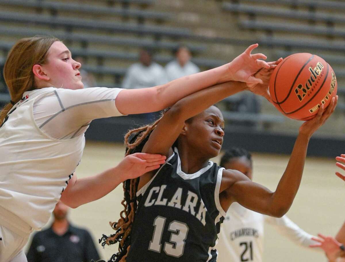 Clark’s Bolu Odumoso (13) grabs a loose ball as Brooke Sandercock, left, of Churchilll, defends during 28-6A basketball action at Littleton Gym on Wednesday, Jan. 4, 2023.