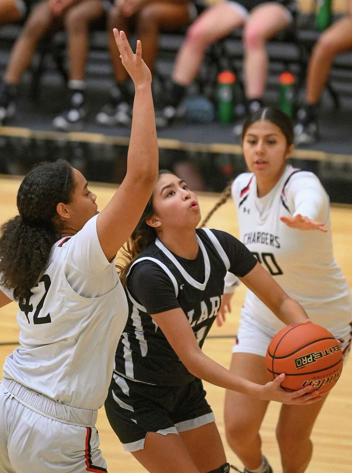 Clark’s Jade Perez (11) penetrates and scores against Churchill defender Kiyona Graham, left, during 28-6A basketball action at Littleton Gym on Wednesday, Jan. 4, 2023.