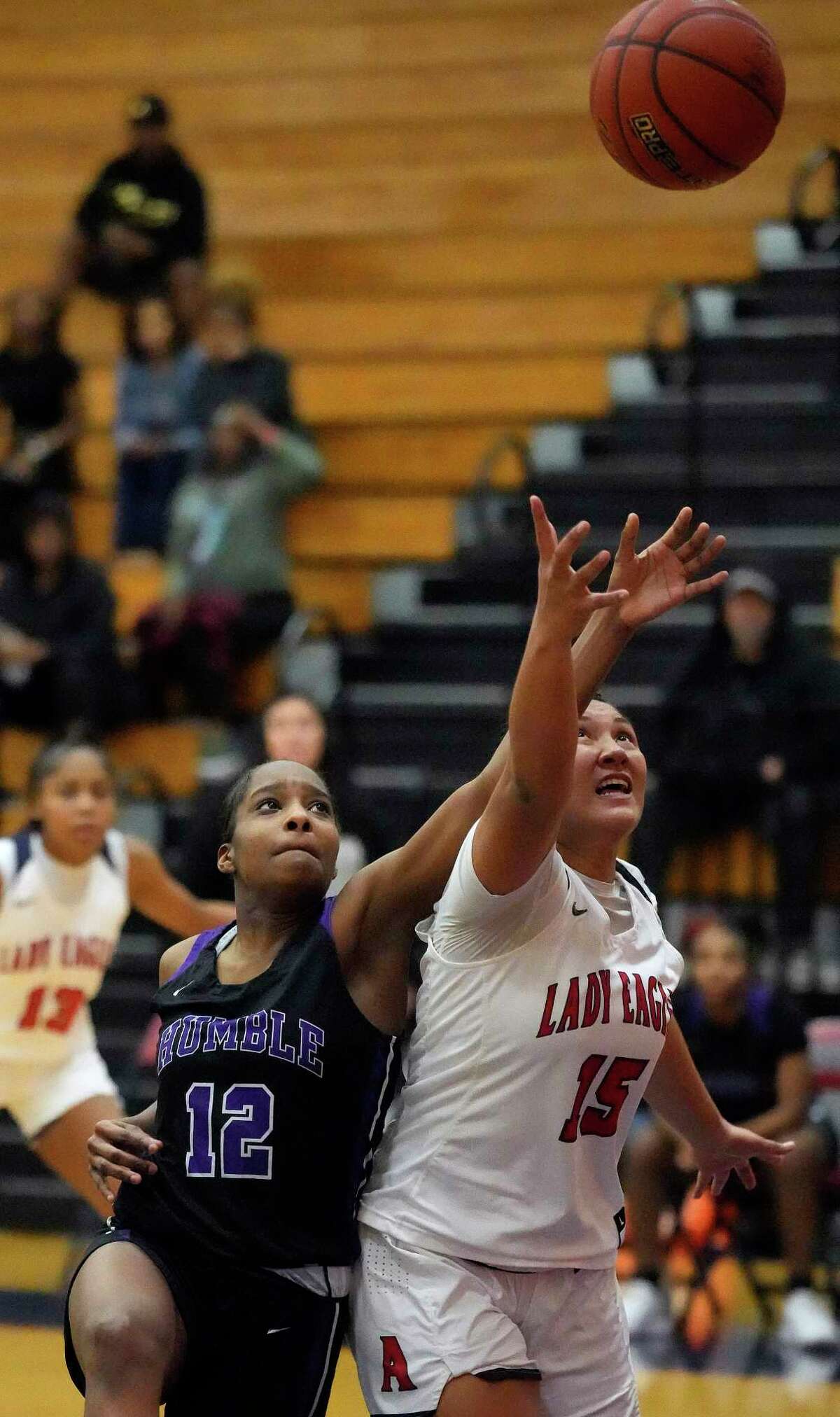 Humble High School's Krystal Cross (12) and Atascocita High School's Zoiey Jumawan (15) reach for a rebound during the second half of a District 21-6A high school girls basketball game at Atascocita High School on Wednesday, Jan. 4, 2023 in Humble.