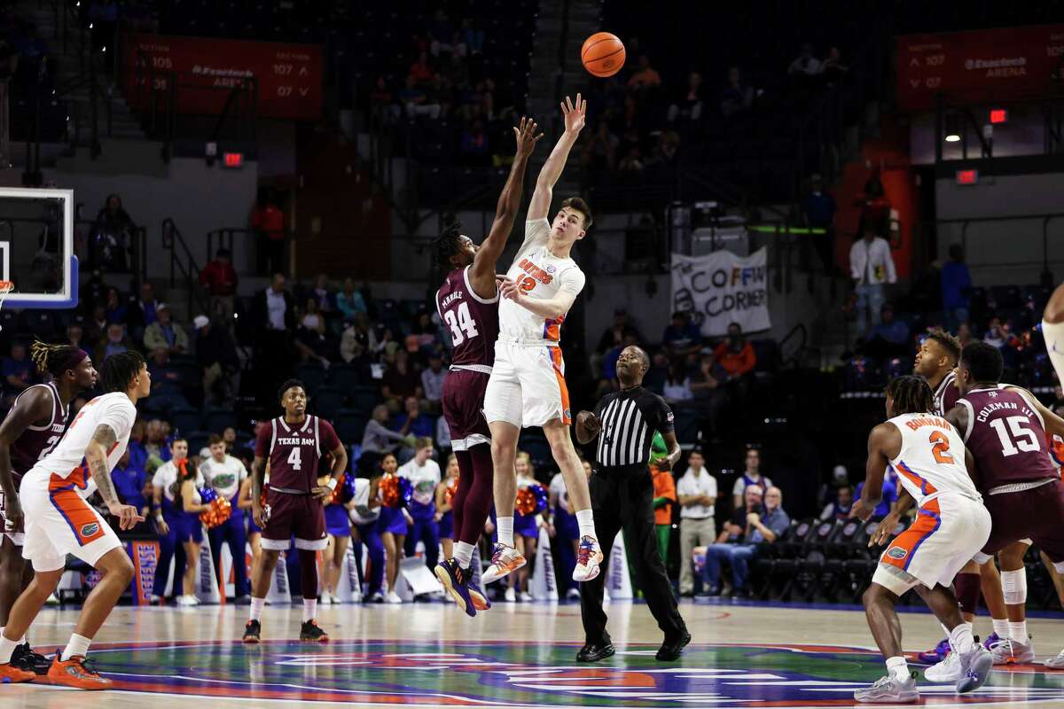 GAINESVILLE, FLORIDA - JANUARY 04: Colin Castleton #12 of the Florida Gators tips the ball against Julius Marble #34 of the Texas A&M Aggies during the first half of a game at the Stephen C. O'Connell Center on January 04, 2023 in Gainesville, Florida.