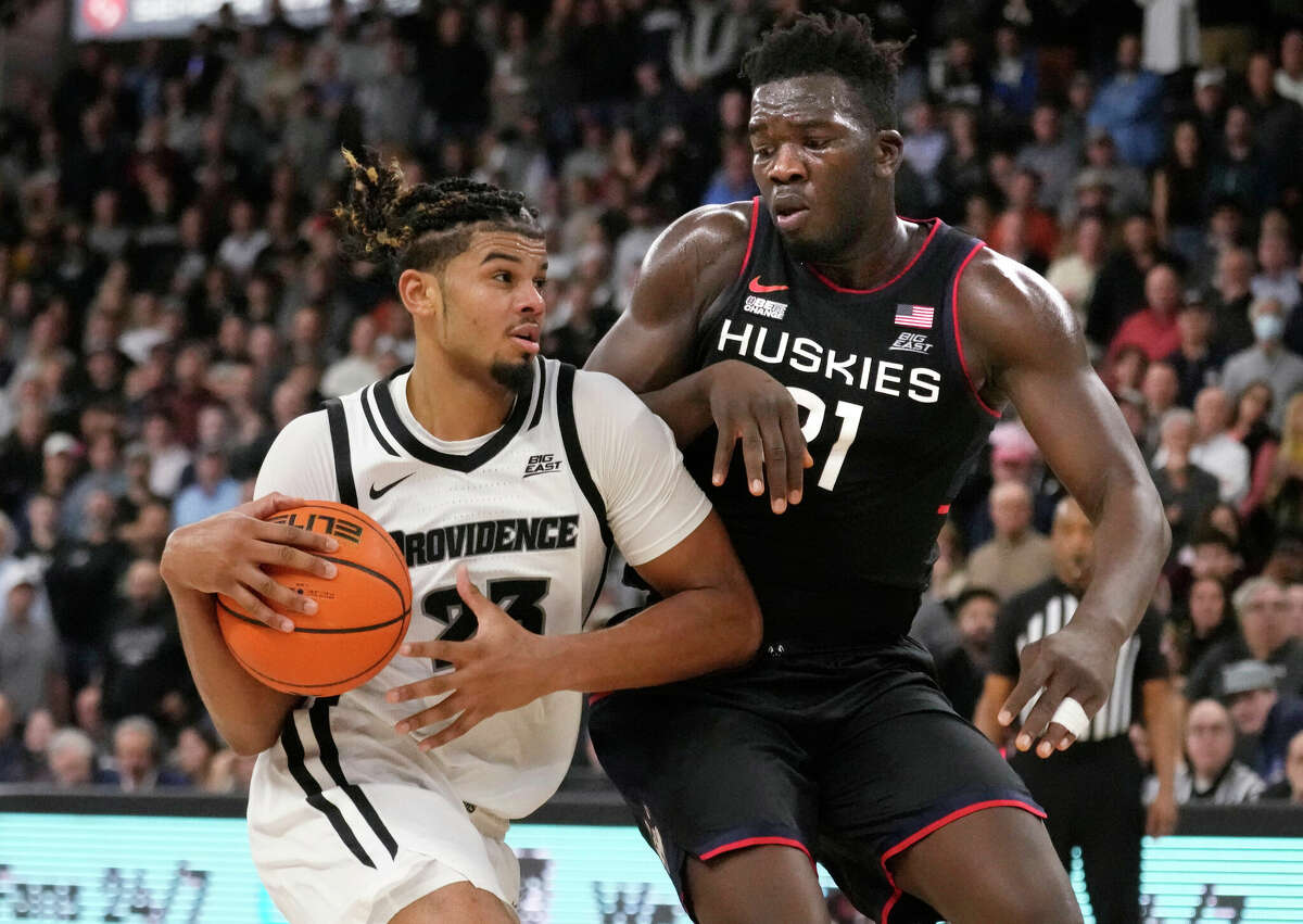 Providence forward Bryce Hopkins (23) drives to the basket against Connecticut forward Adama Sanogo (21) during the second half of an NCAA college basketball game, Wednesday, Jan. 4, 2023, in Providence, R.I. Providence upset #4 Connecticut 73-61. (AP Photo/Charles Krupa)