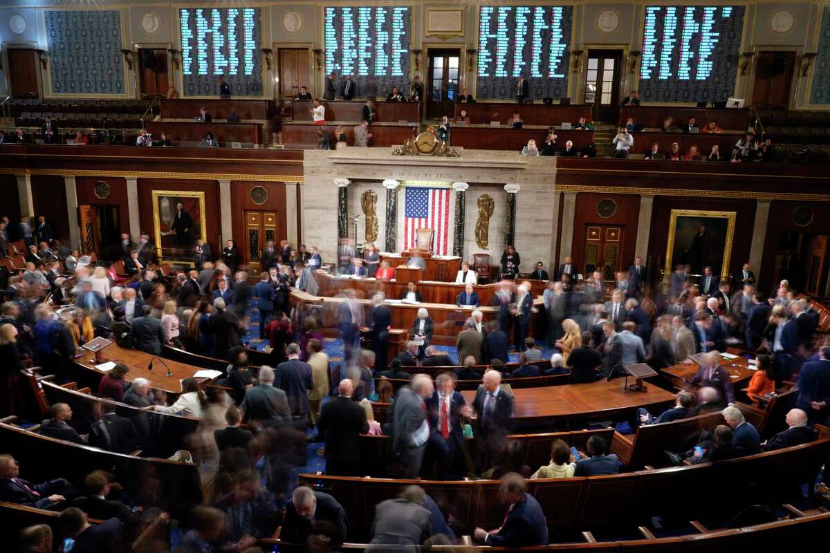 Members walk on the House floor in the House chamber during a roll call vote on the motion to adjourn as the House meets for a second day to elect a speaker and convene the 118th Congress in Washington, Wednesday, Jan. 4, 2023.
