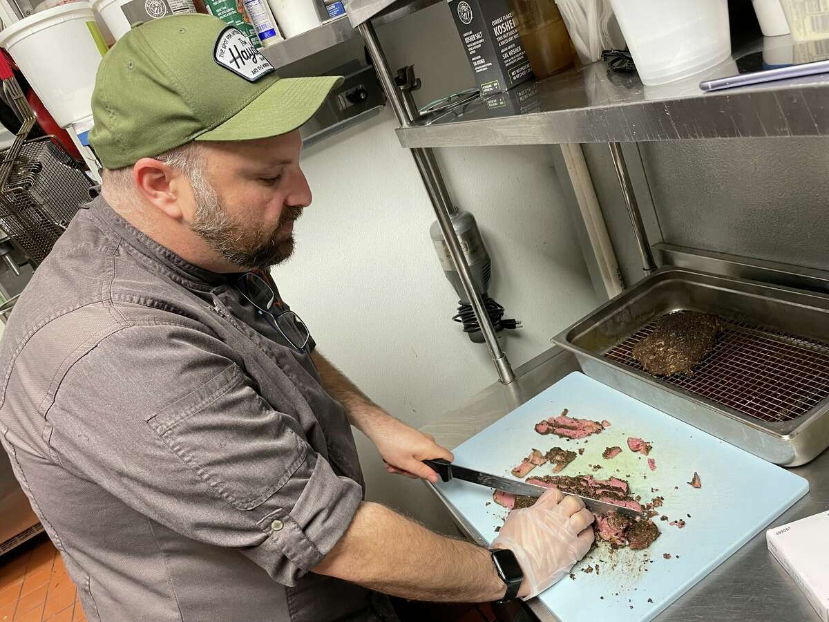 Bill Corbett, executive chef at The Hayden, slices up a fresh batch of pastrami for sandwiches at the restaurant.