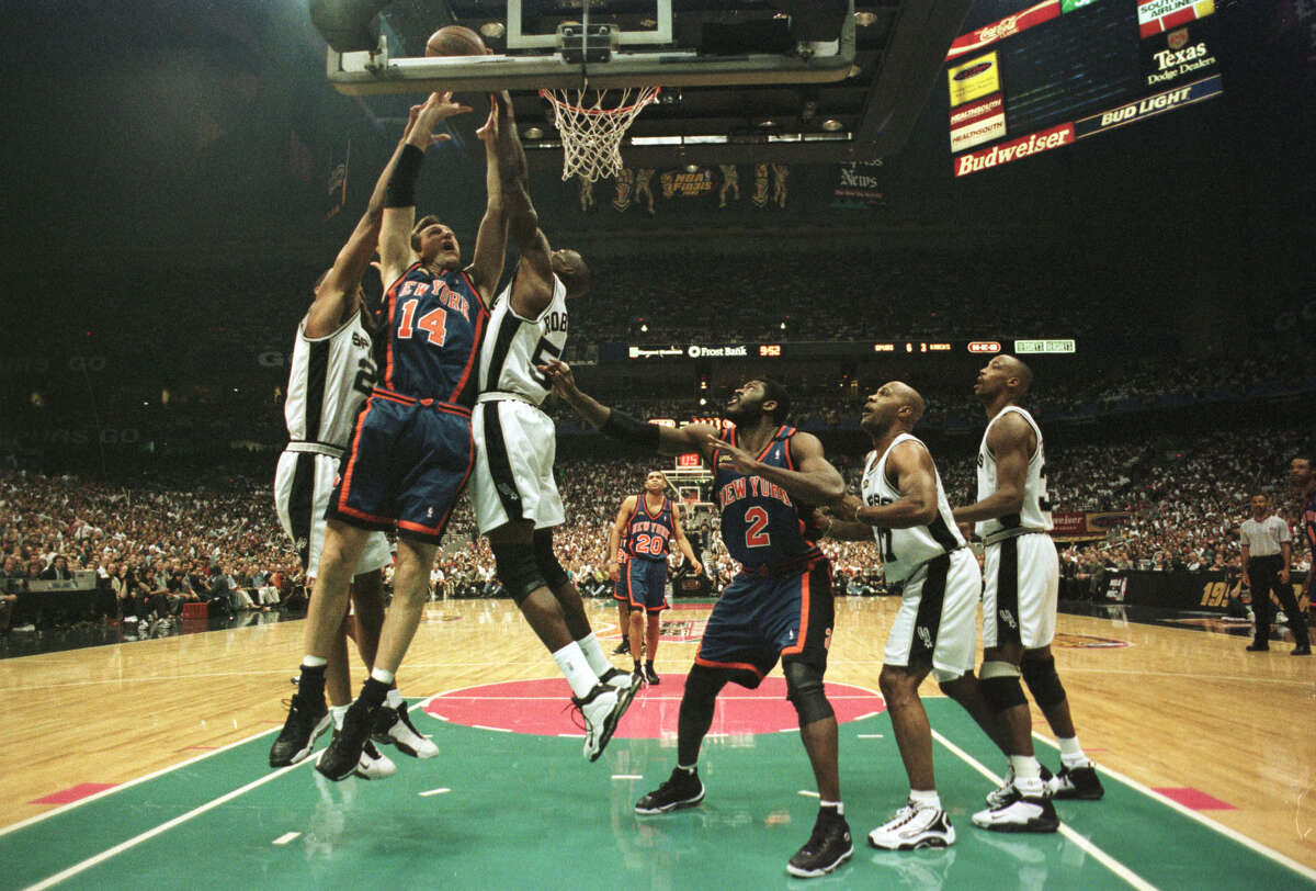 18 Jun 1999: Chris Dudley #14 of the New York Knicks gets hammered as he goes to the basket by Tim Duncan #21 and David Robinson #50 of the San Antonio Spurs during game two of the NBA Finals at the Alamodome in San Antonio, Texas. Mandatory Credit: Matthew Stockman/ALLSPORT