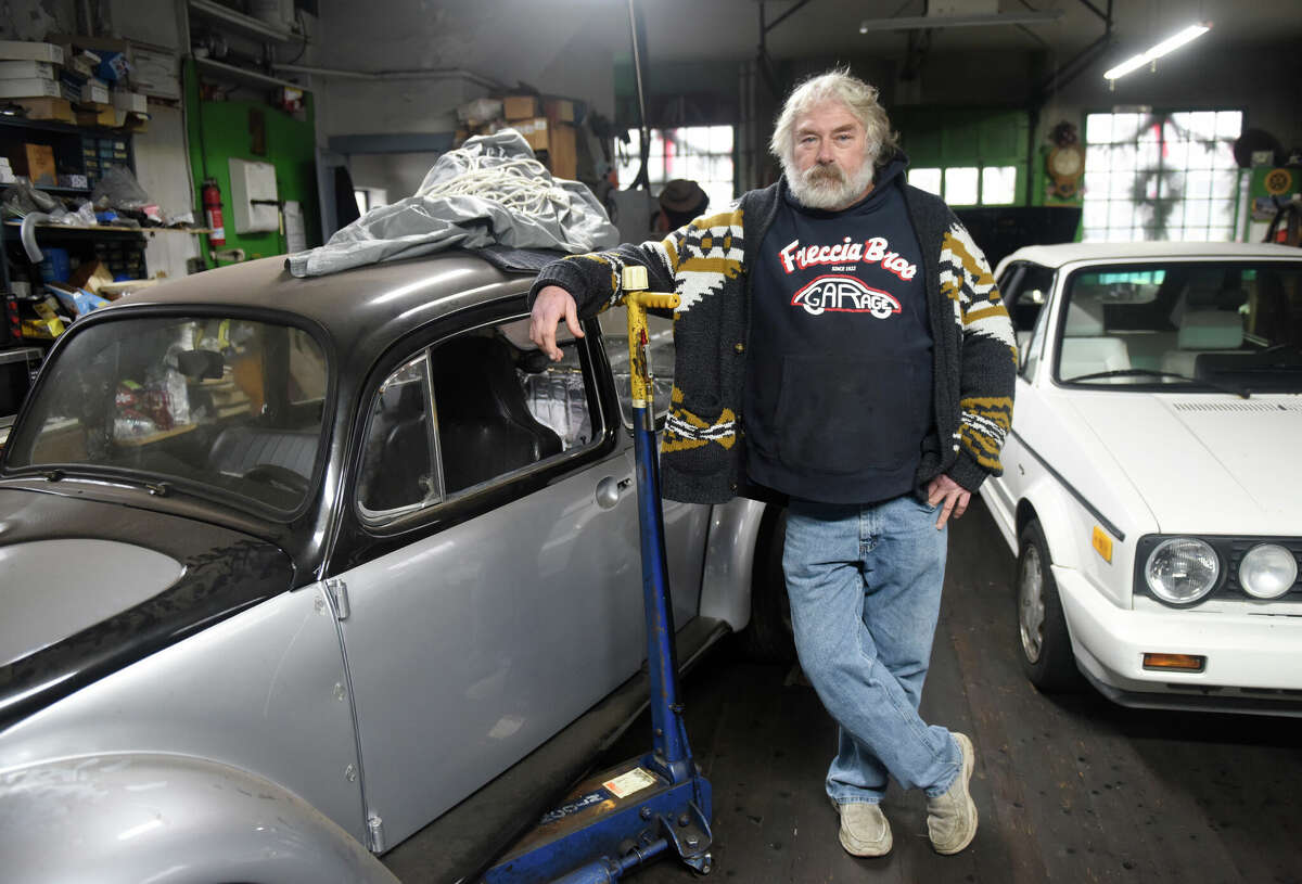 Shop owner Frank Freccia III poses at Freccia Brothers Garage in Greenwich, Conn. Thursday, Jan. 5, 2023. The shop just celebrated its 100th anniversary with a proclamation from First Selectman Fred Camillo. Freccia Brothers was founded in 1922 and became a Volkswagen speciality shop in 1960.