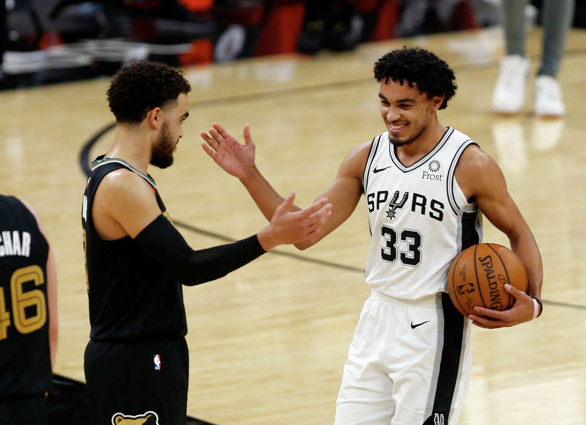 No. 21 Tyus Jones of the Memphis Grizzlies high-fives his brother Tre Jones No. 33 of the San Antonio Spurs at the end of the game at the AT&T Center on January 30, 2021 in San Antonio, Texas.
