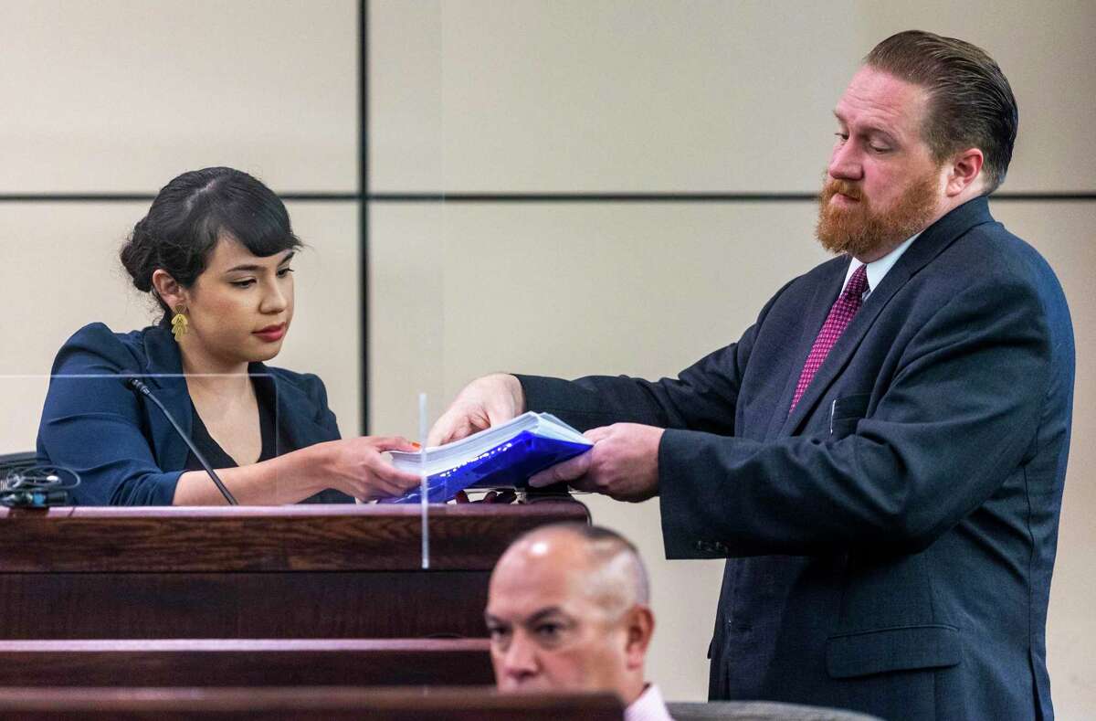 Susan Tristan, the former Precinct 2 custodian of records, receives documents Aug. 29, 2022 from attorney Jason Goss while testifying in the evidence tampering trial of former Bexar County Precinct 2 Constable Michelle Barrientes Vela.