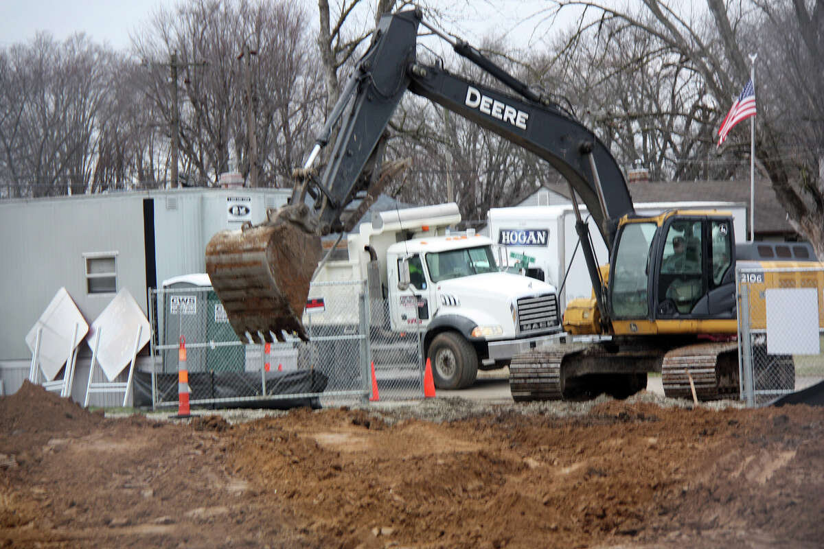 A backhoe works on some soil at the construction entrance Thursday. 