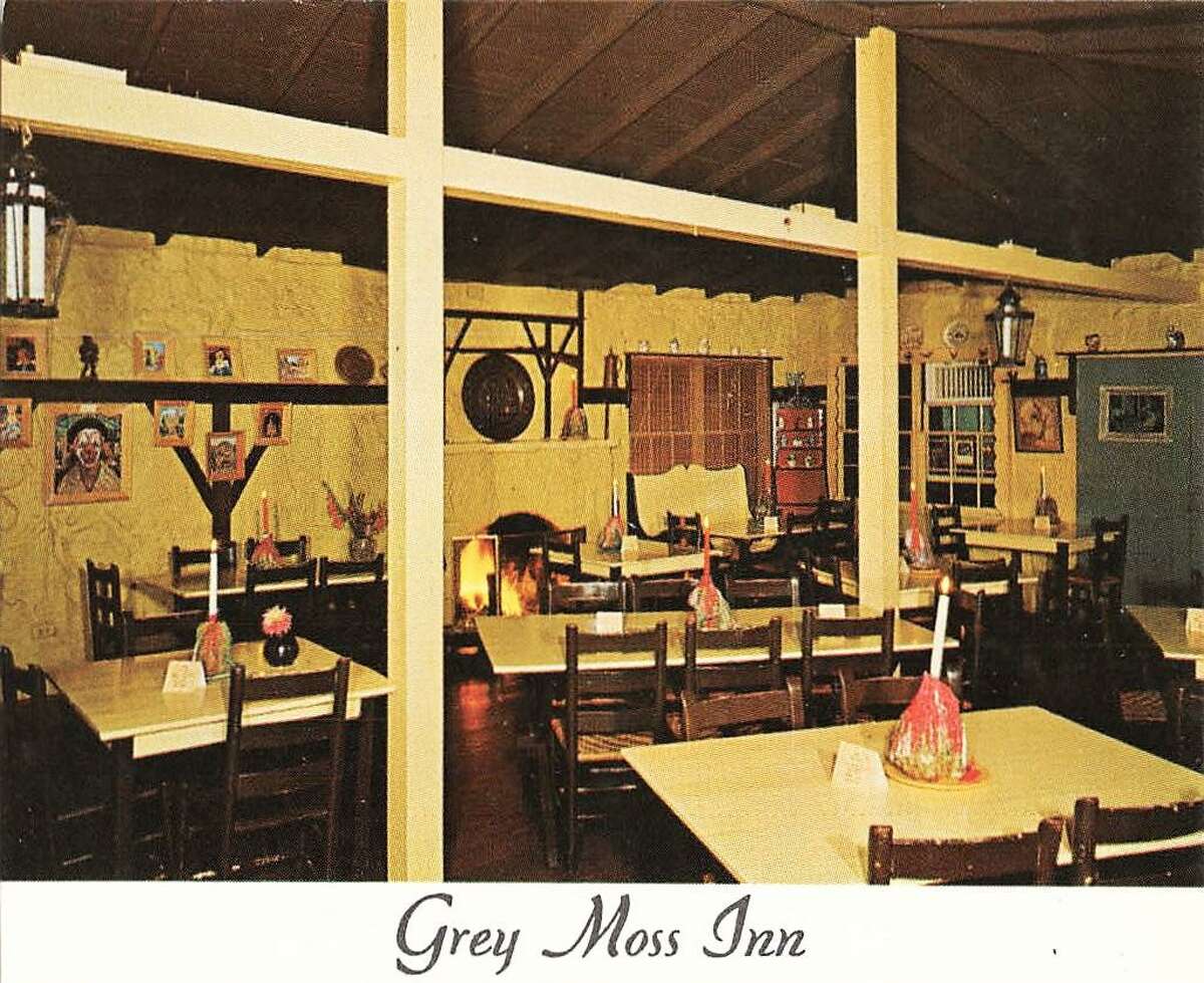 The interior dining room at Grey Moss Inn circa 1960 had a fireplace original to the 1920s building, art provided by members of the Grey Forest artists colony and tables centered with candles stuck in the multicolored drippings of previous candles.