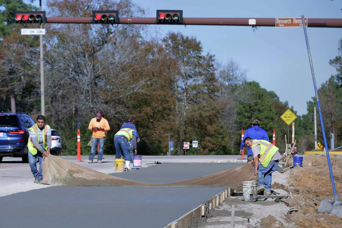 Workers smooth fresh concrete for a right turn lane at Kuykendahl Road and Research Forest Drive in The Woodlands.
