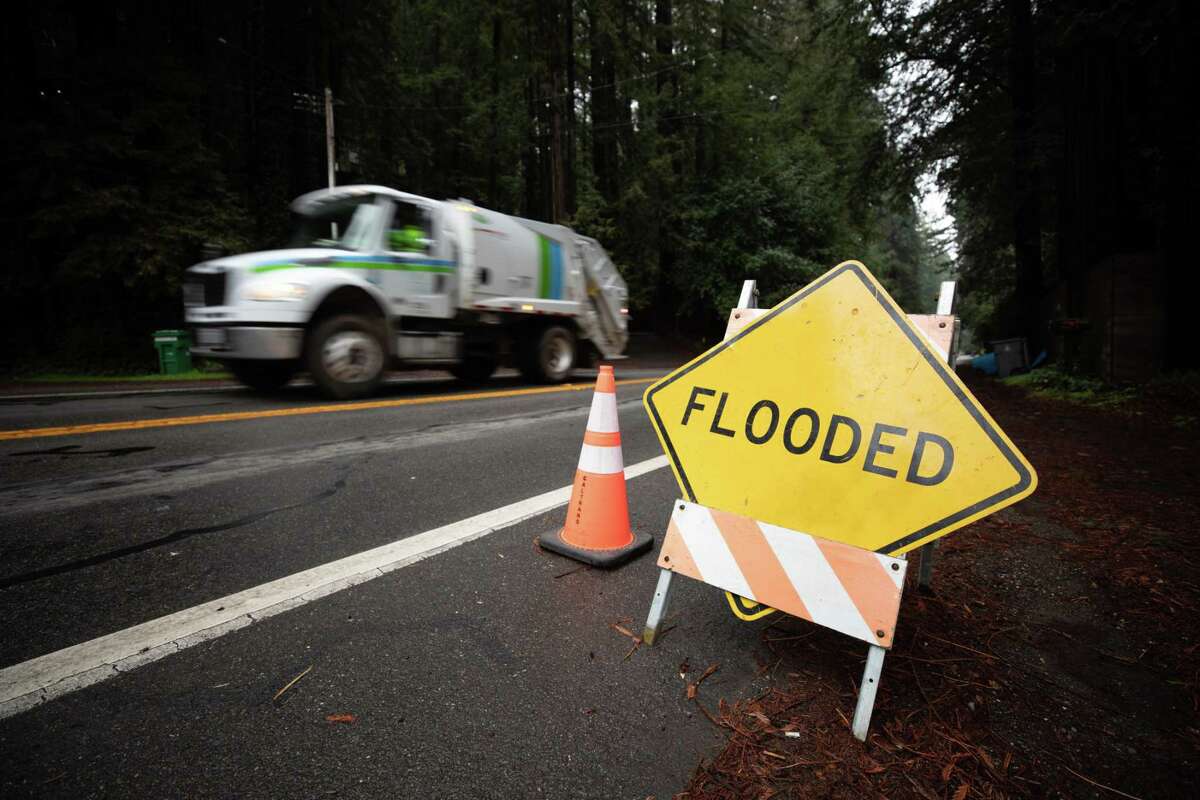 A sign on River Road in Guerneville warns of flooding on the roadway on Tuesday. With more storms on the way, officials say it’s likely the Russian River would tip over its banks Sunday afternoon,