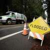 一个flooded sign stands on River Road in Guerneville, Calif. on Tuesday, Jan 3, 2023. Heavy rain is expected throughout Northern California including the possibility of flooding.