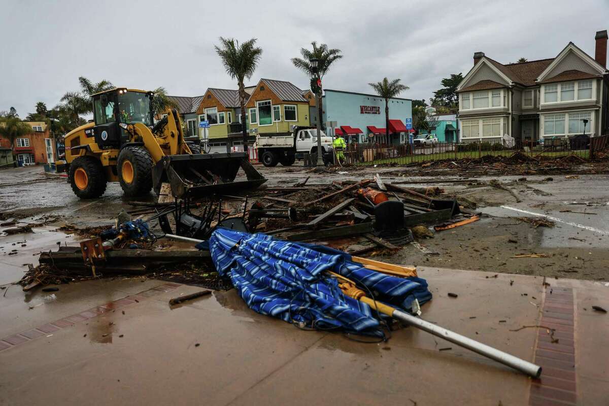 Crews clean up debris in Capitola after the waterfront was slammed by huge swells.
