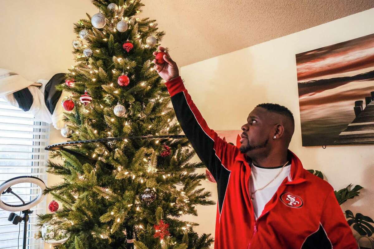 Patrick Moten, disabled by an on-the-job injury, takes down ornaments from his Christmas tree.