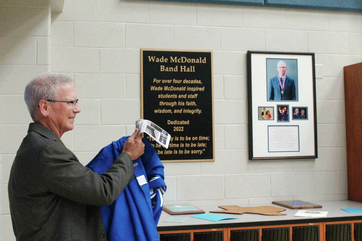 Former McAdams Junior High School band director Wade McDonald reacts after the unveiling of a plaque naming the school's band hall in his honor.