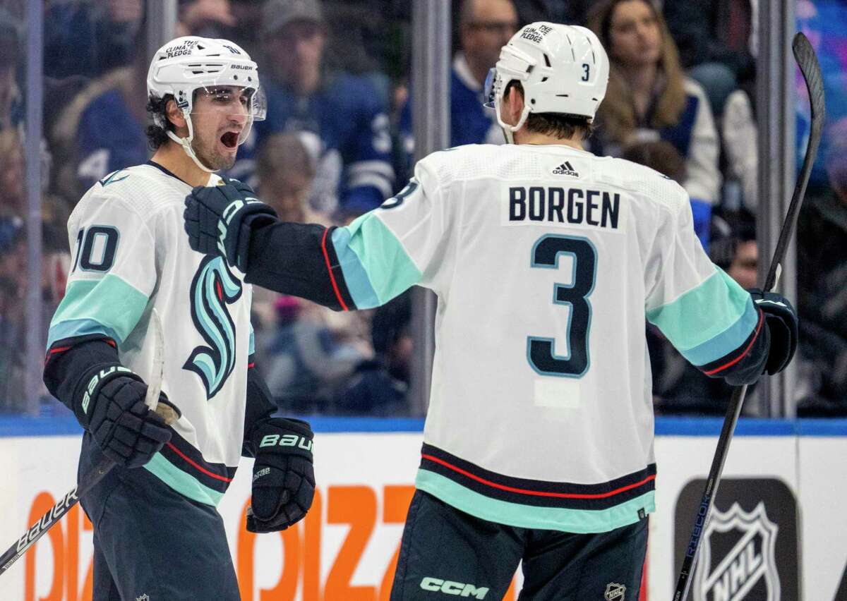 Seattle Kraken center Matty Beniers (10) celebrates his goal against the Toronto Maple Leafs with Will Borgen (3) during the second period of an NHL hockey game Thursday, Jan. 5, 2023, in Toronto. (Frank Gunn/The Canadian Press via AP)