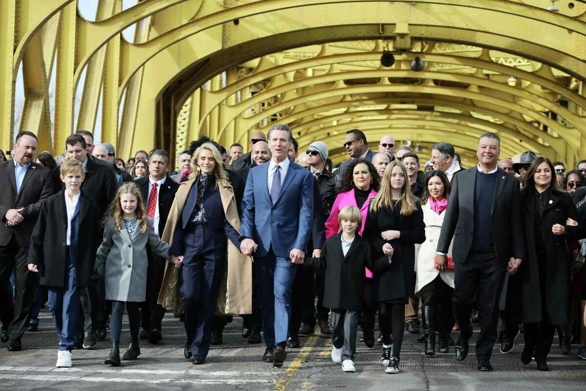 Gov. Gavin Newsom marches with his family and supporters on the Tower Bridge before his inauguration.