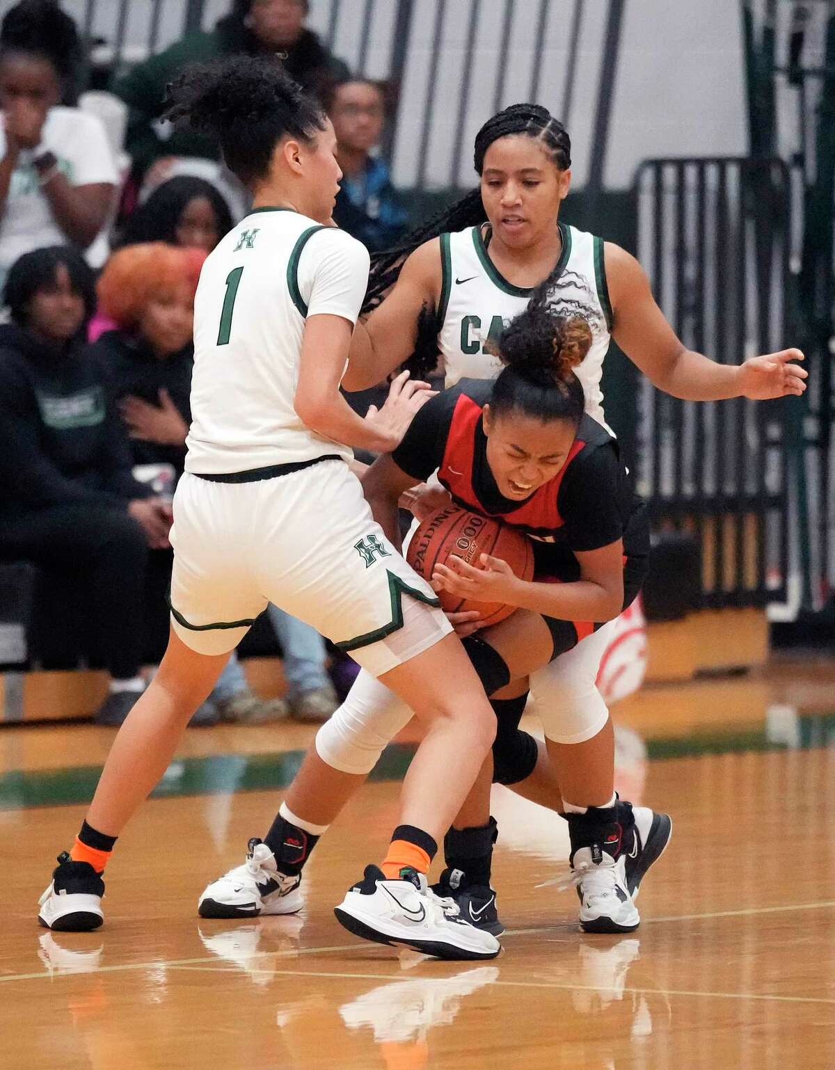 Fort Bend Austin's Aminah Dixon (4) is squeezed by Hightower High School's Kailee Beaudion (1) and Chandler Caver (3) during the second half of a District 20-6A girls basketball game at Hightower High School on Friday, Jan. 6, 2023 in Missouri City. Fort Bend Austin beat Hightower 26-23.