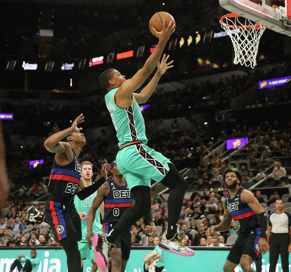 Spurs’ Keldon Johnson (03) drives past Detroit Pistons’ Jaden Ivey (23) during their game at the AT&T Center on Friday, Jan. 6, 2023. Johnson later left the floor with a hamstring injury and did not return for the rest of the game.