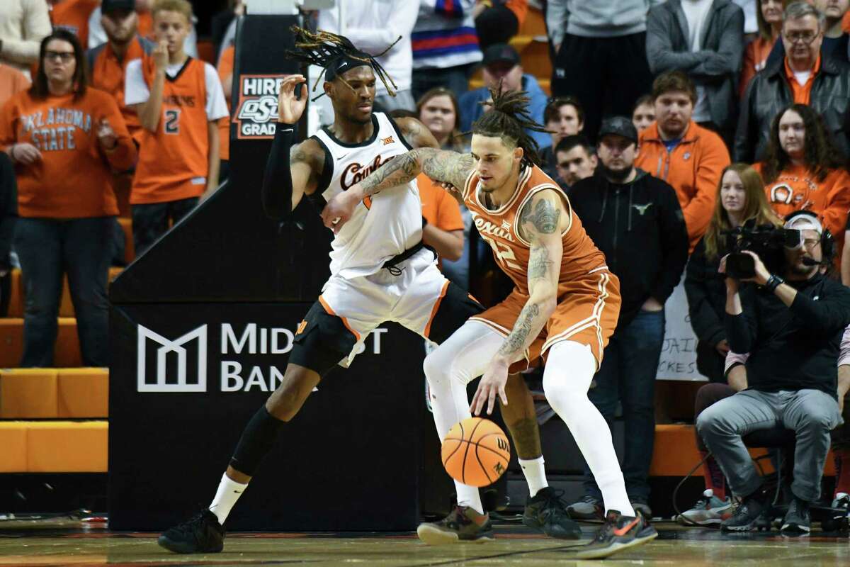 Texas forward Christian Bishop (32) fends off Oklahoma State forward Tyreek Smith (23) under the basket during the first half of an NCAA college basketball game Saturday, Jan. 7, 2023, in Stillwater, Okla. (AP Photo/Brody Schmidt)
