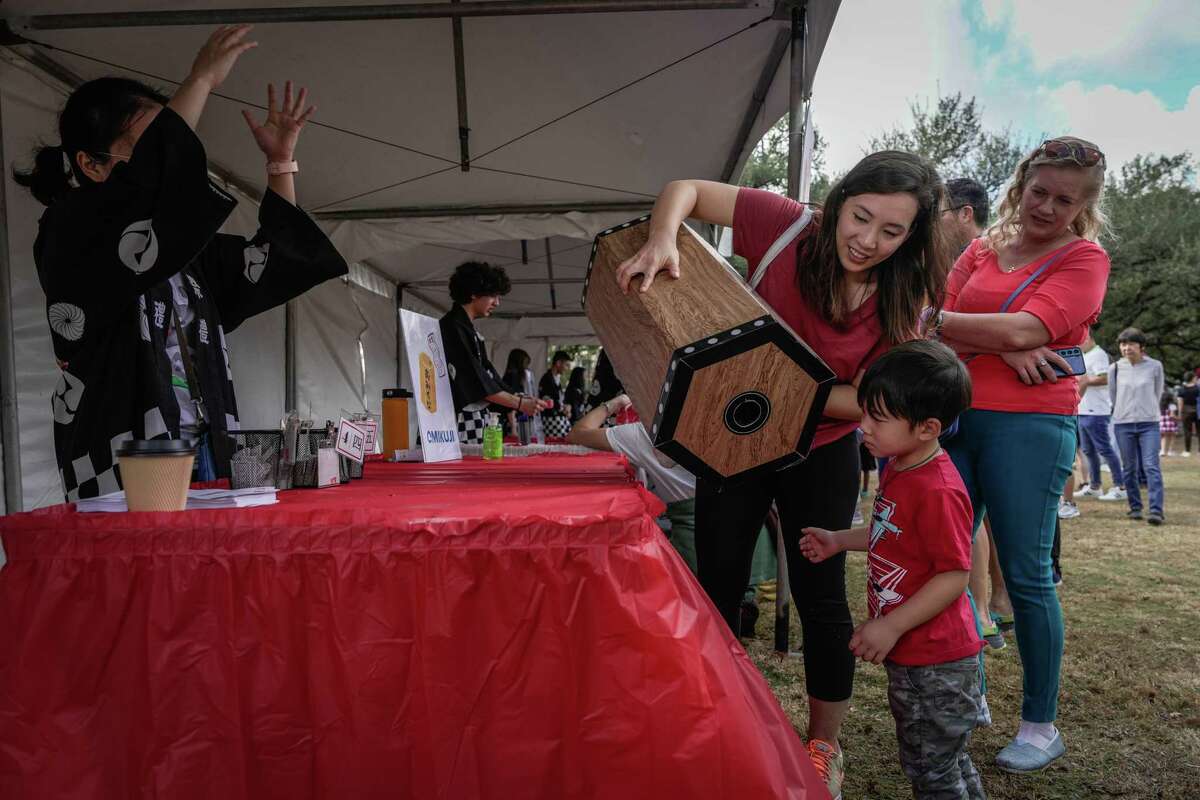 Lisa Quach and her son Leo Quach, 3, participate in a fortune booth at the Japanese New Year on Saturday, Jan. 7, 2023 at Levy Park Pavilion in Houston.