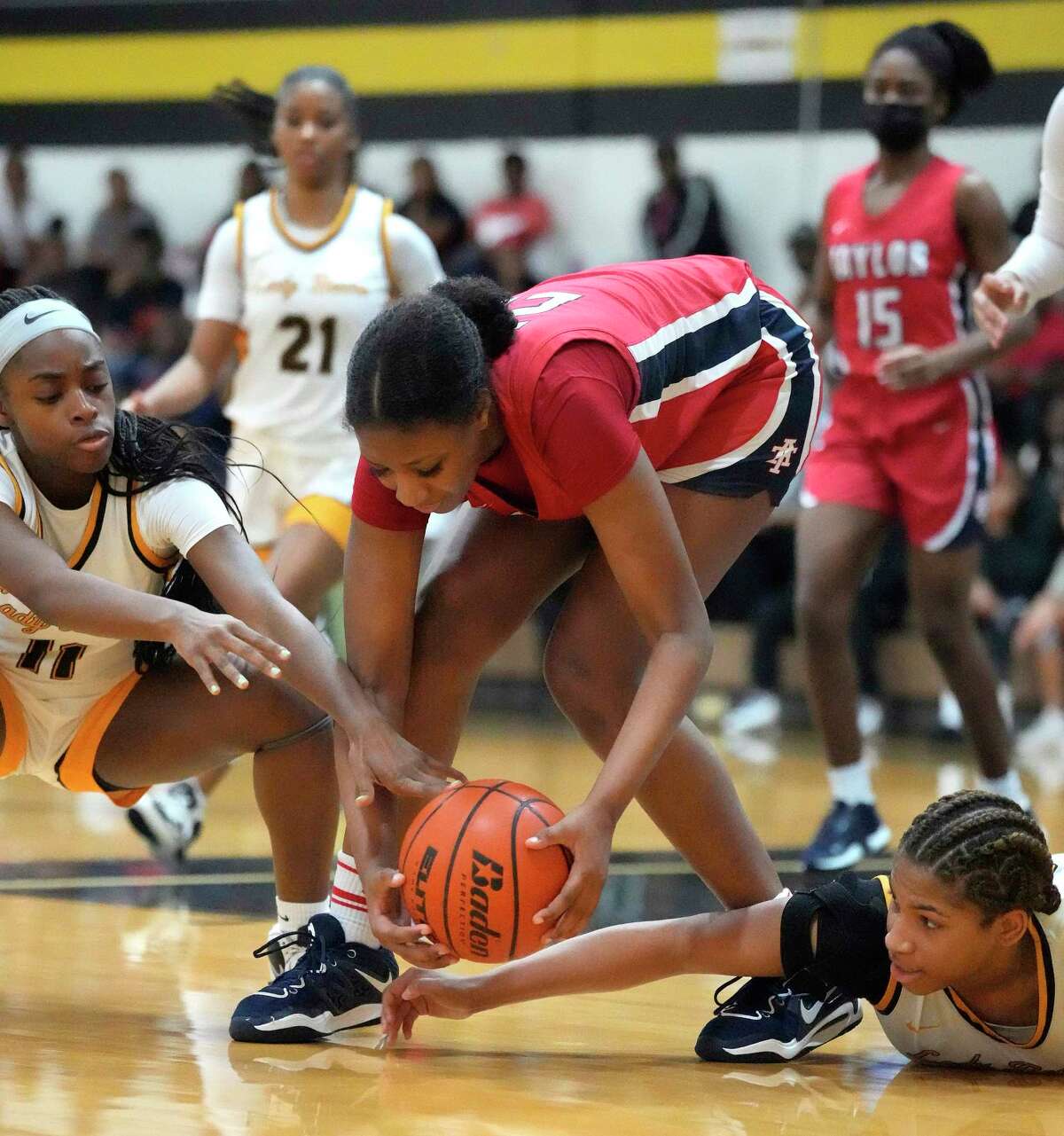 Alief Taylor's Nataliyah Gray (22) tries to hang onto the ball against Hasting High School's Domitila Amugu (11) and her teammate Melinda Winston (23) during the second half of a District 23-6A girls basketball game at Hastings High School on Saturday, Jan. 7, 2023 in Houston. Hasting High School won the game 52-45 against Alief Taylor.