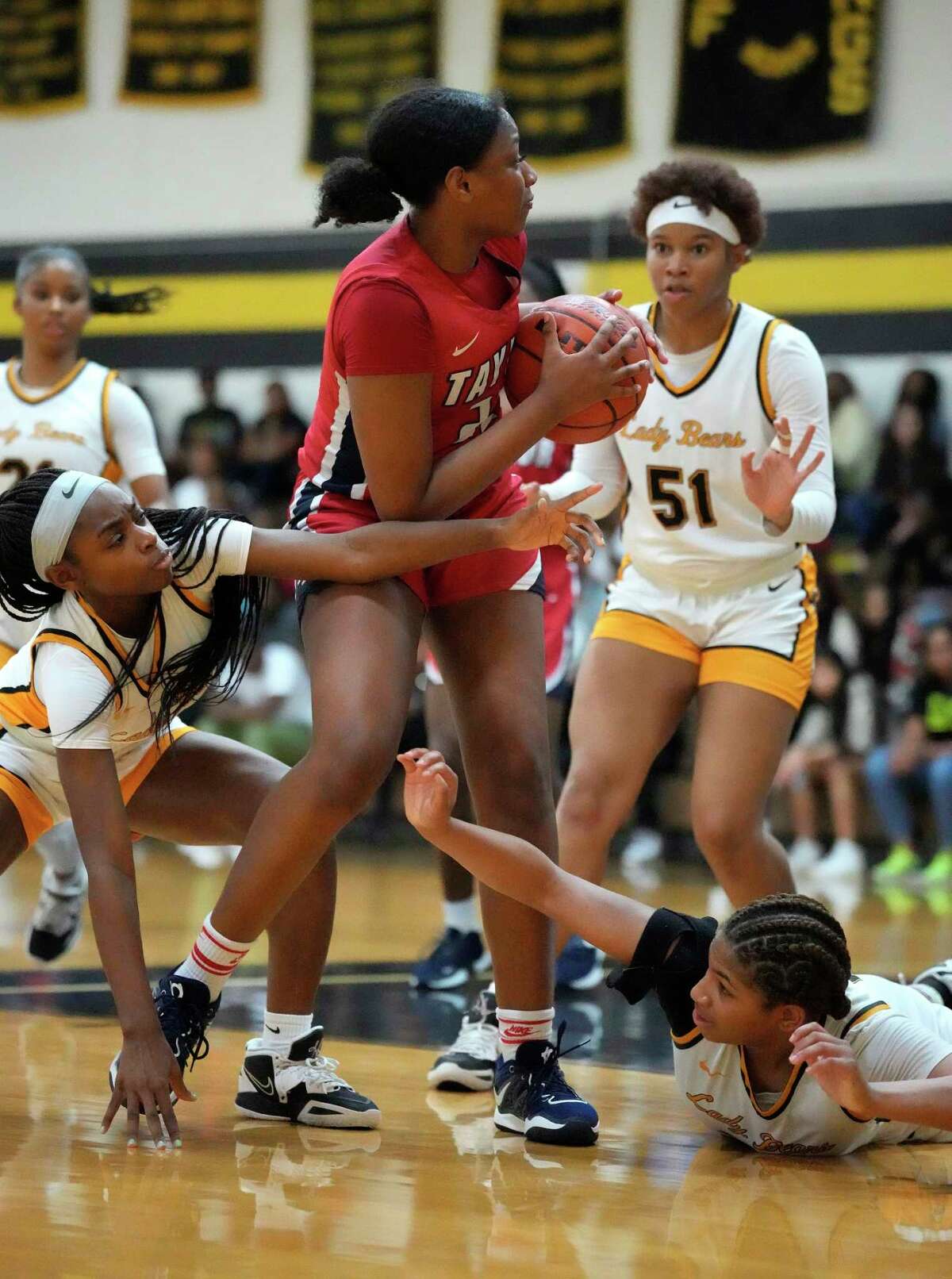 Alief Taylor's Nataliyah Gray (22) tries to hang onto the ball against Hasting High School's Domitila Amugu (11) and her teammate Melinda Winston (23) during the second half of a District 23-6A girls basketball game at Hastings High School on Saturday, Jan. 7, 2023 in Houston. Hasting High School won the game 52-45 against Alief Taylor.