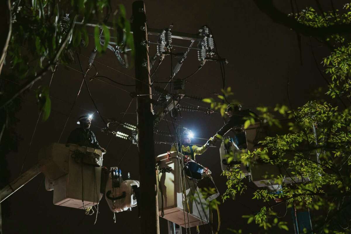 Late on Friday night, PG&E employees worked to repair damaged power lines in San Francisco’s St. Mary’s Park neighborhood.