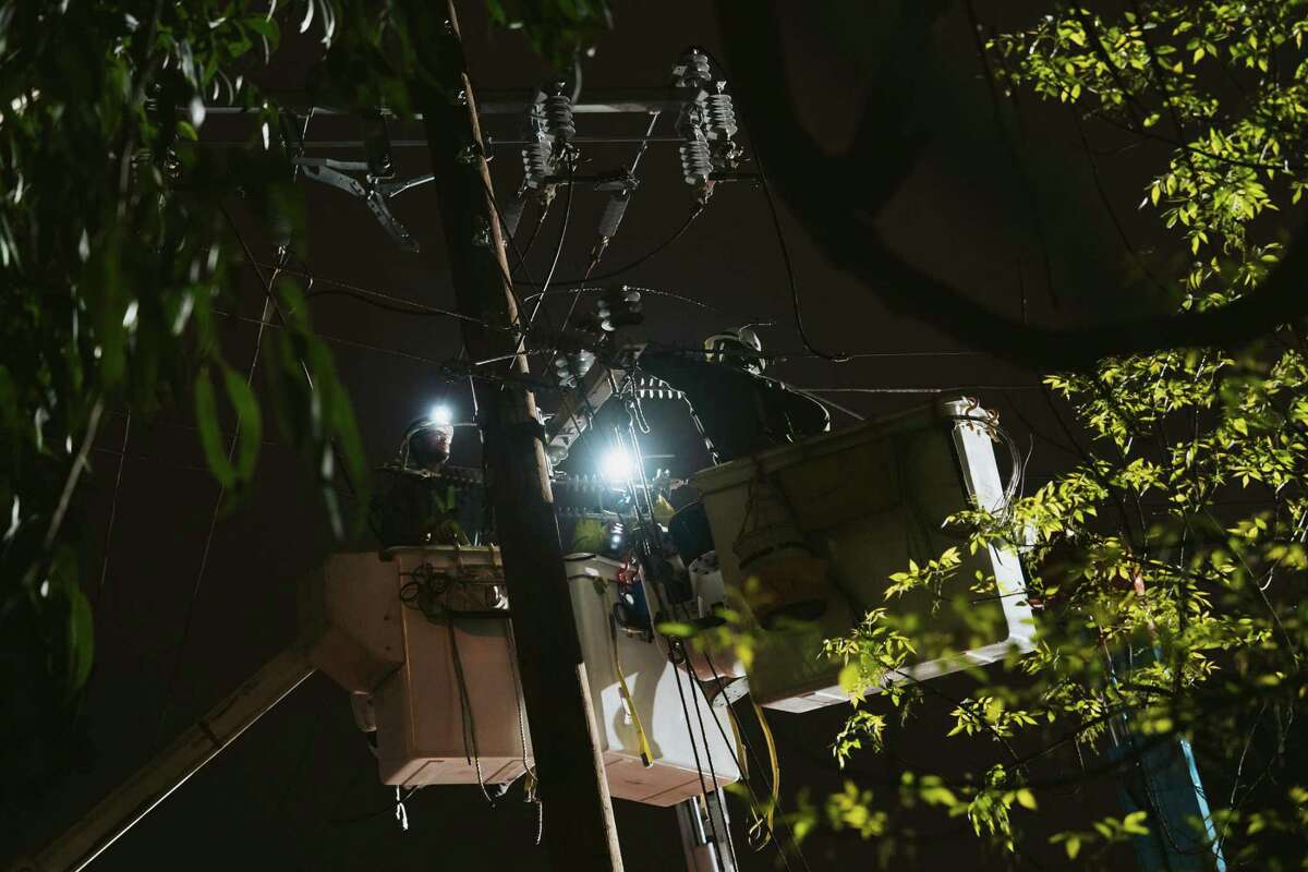 Late on Friday night, PG&E employees work on repairing damage to power lines in San Francisco’s St. Mary’s Park neighborhood sustained from a fallen eucalyptus tree during Wednesday’s storms.